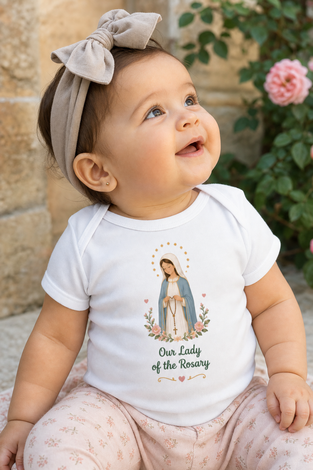 Baby girl wearing the Our Lady of the Rosary bodysuit in a lifestyle setting — detail