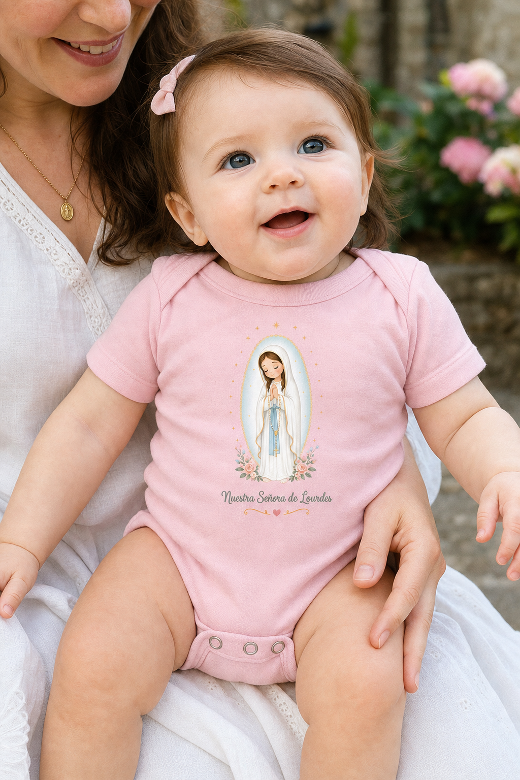 Baby girl wearing the Nuestra Señora de Lourdes bodysuit in a lifestyle setting — detail