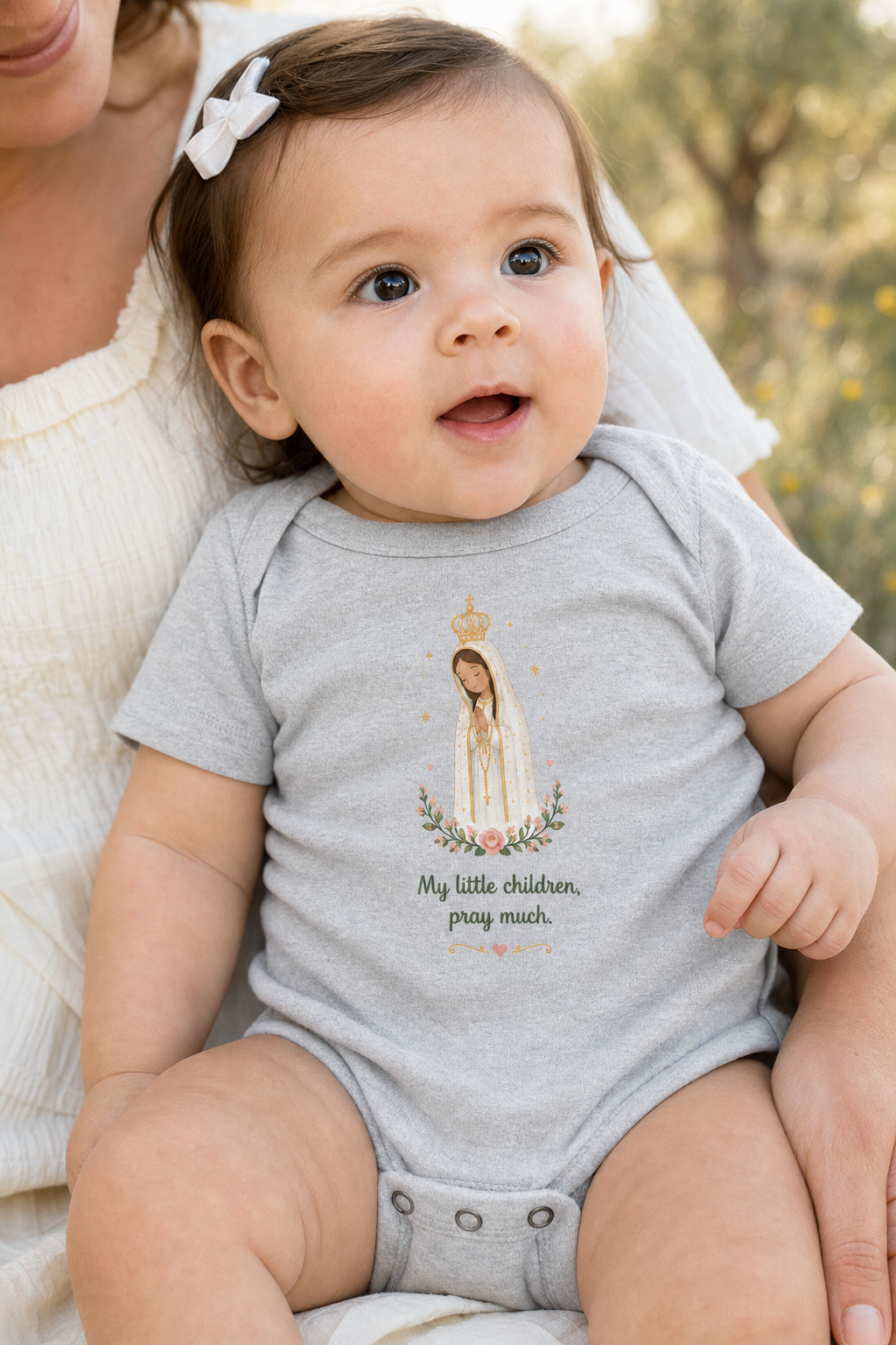 Baby girl wearing the Pray Much Fátima bodysuit in a lifestyle setting — detail