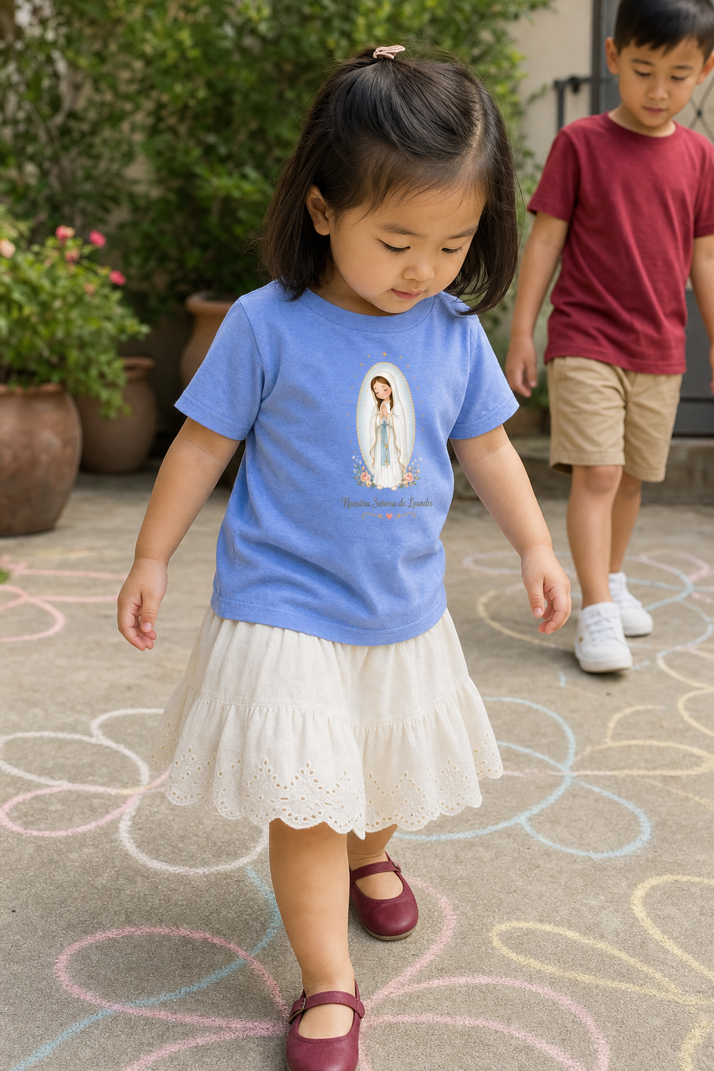 Little girl wearing the Nuestra Señora de Lourdes Toddler T-Shirt in Heather Columbia Blue