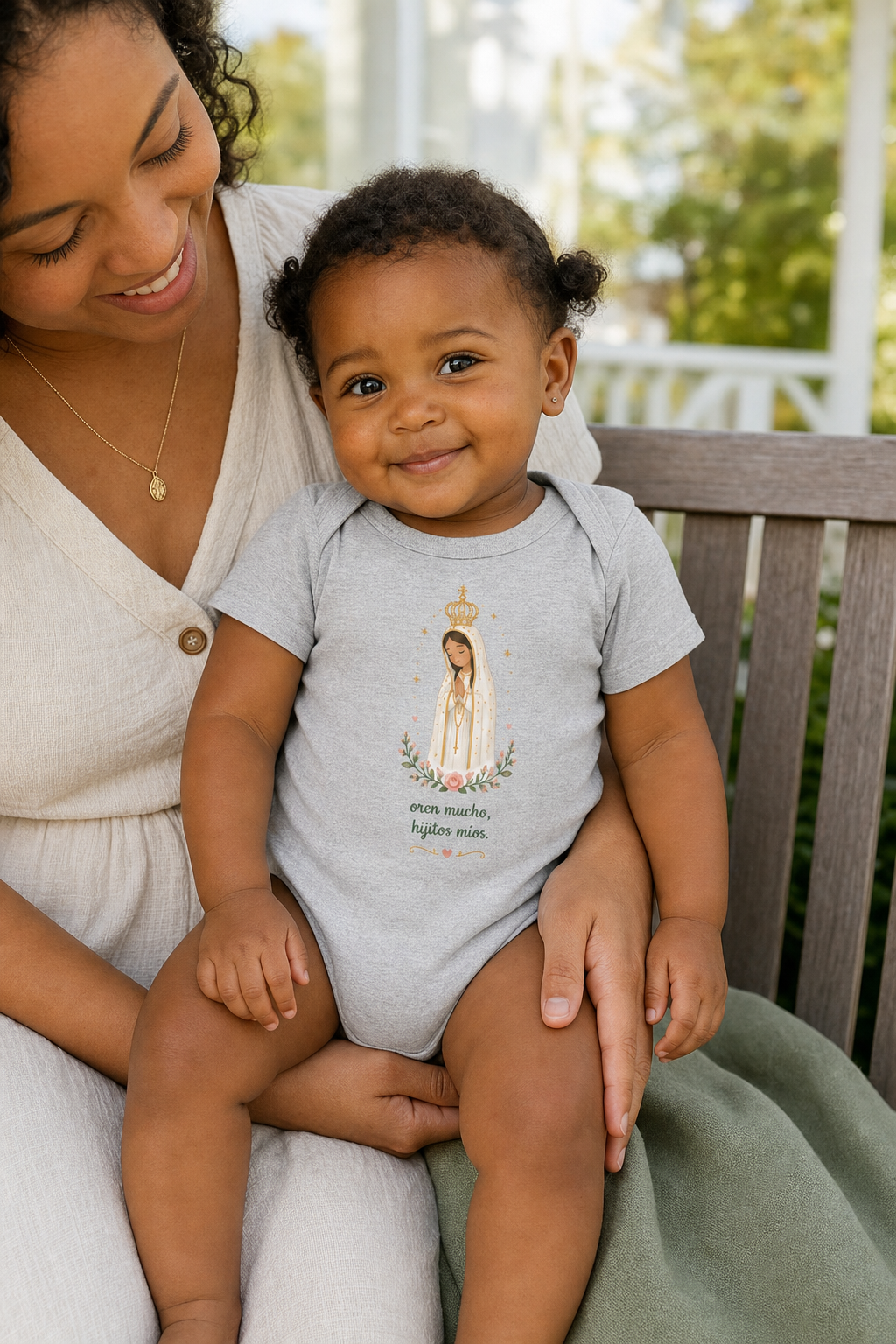 Baby girl wearing the Oren Mucho Fátima Baby Bodysuit in Athletic Heather