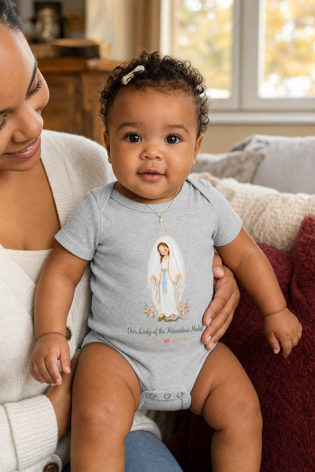 Baby girl wearing the Our Lady of the Miraculous Medal Baby Bodysuit in Athletic Heather