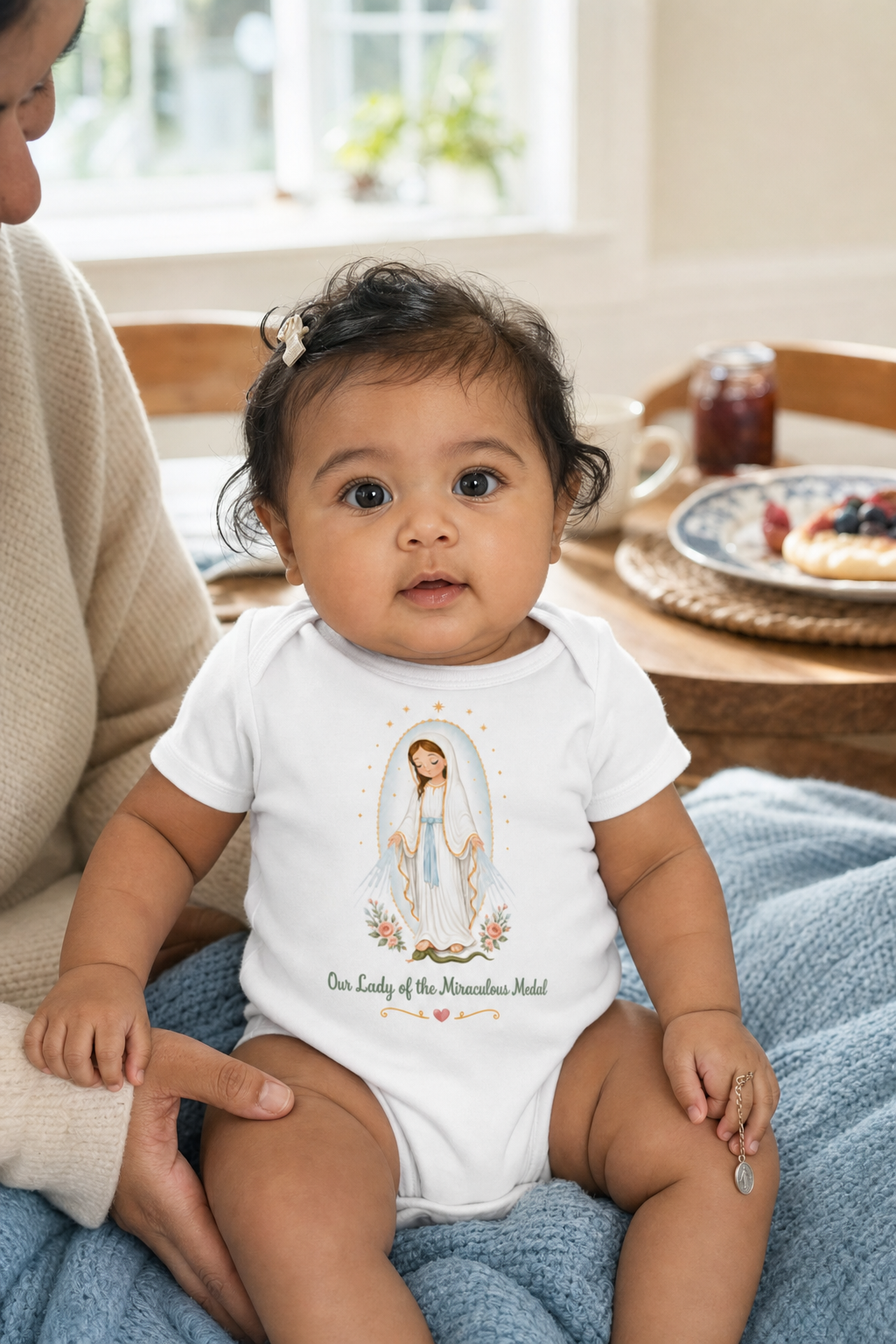 Baby girl wearing the Our Lady of the Miraculous Medal Baby Bodysuit in White
