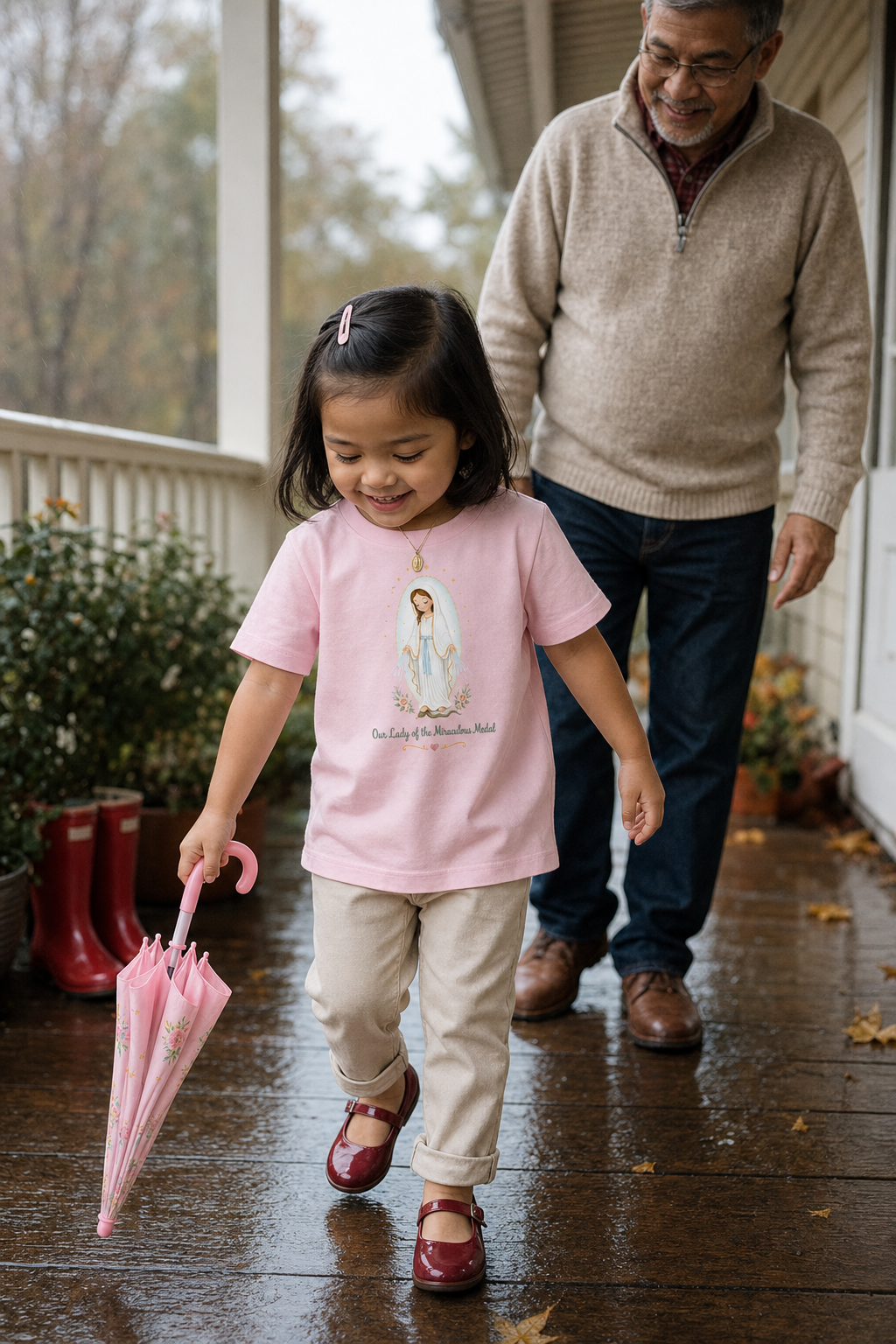 Little girl wearing the Our Lady of the Miraculous Medal Toddler T-Shirt in Pink