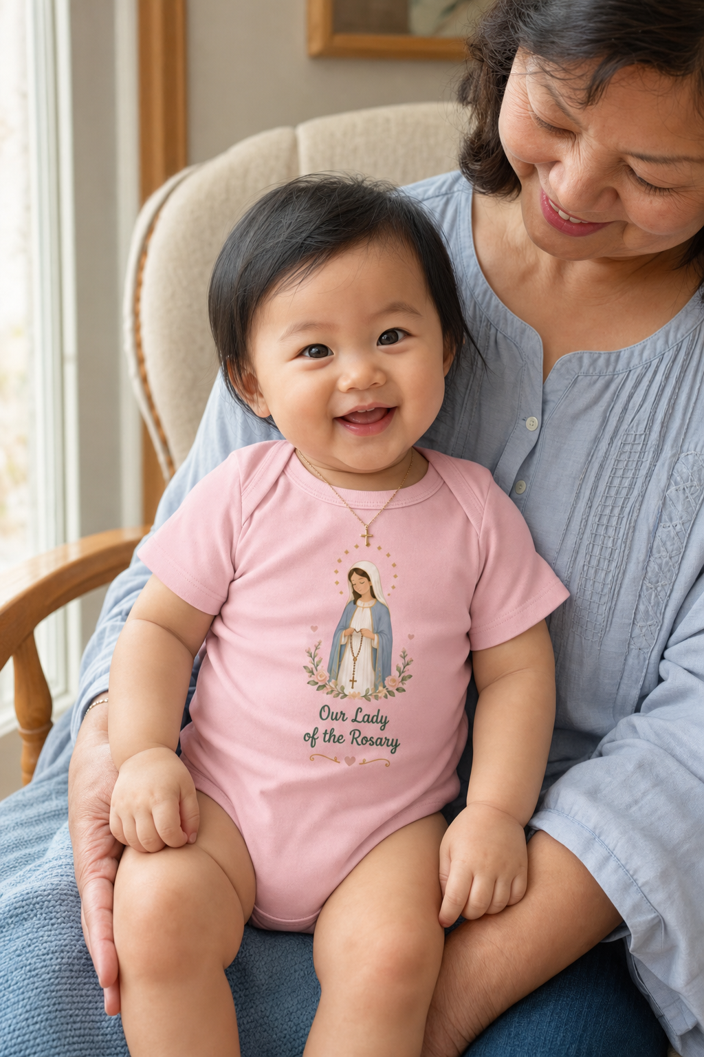 Baby girl wearing the Our Lady of the Rosary Baby Bodysuit in Pink