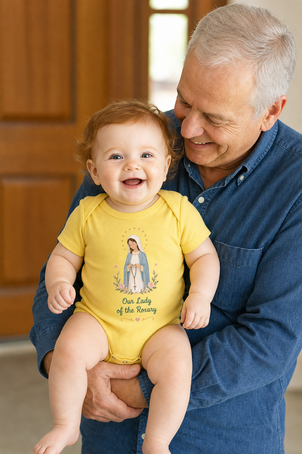 Baby girl wearing the Our Lady of the Rosary Baby Bodysuit in Yellow