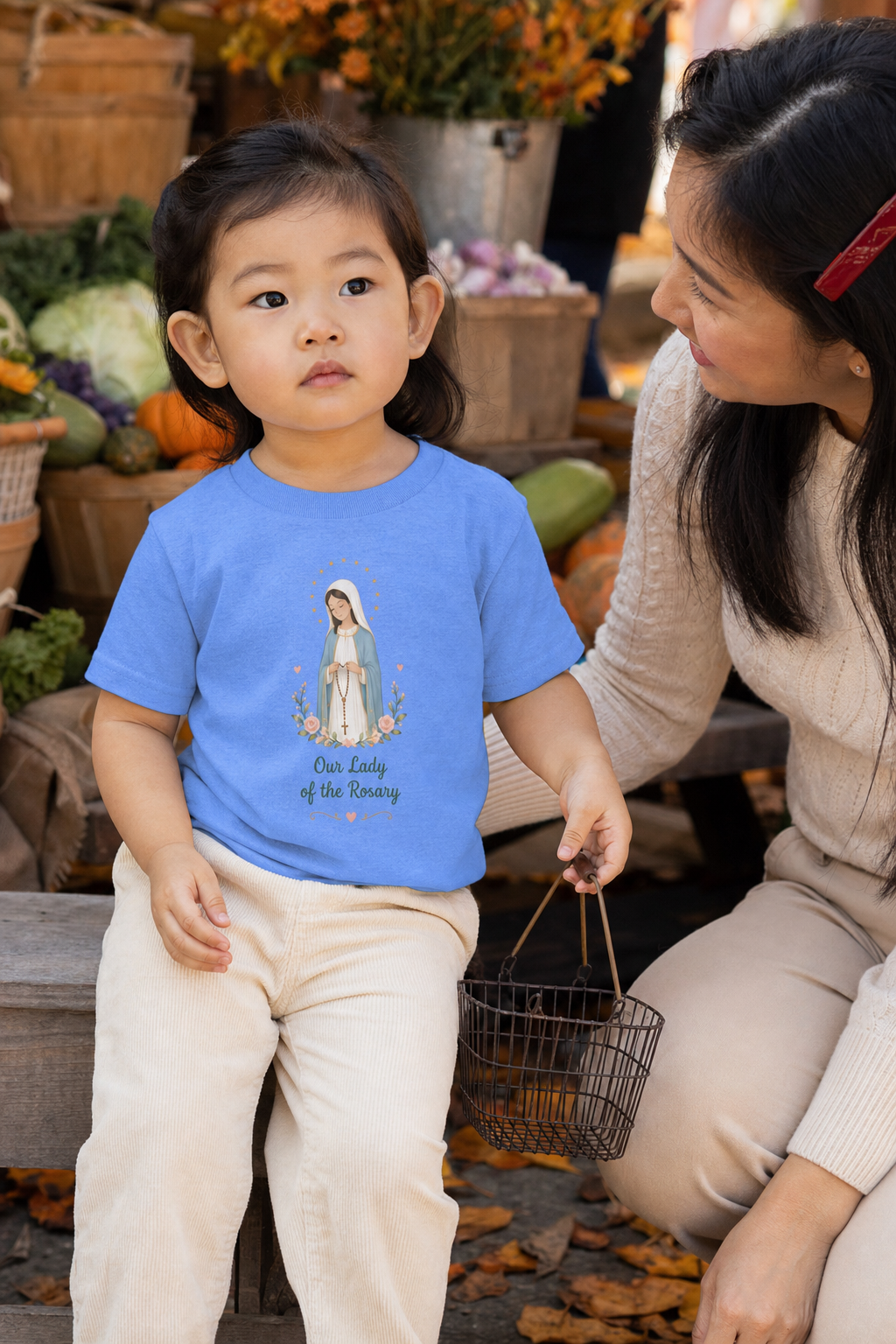 Little girl wearing the Our Lady of the Rosary Toddler T-Shirt in Heather Columbia Blue