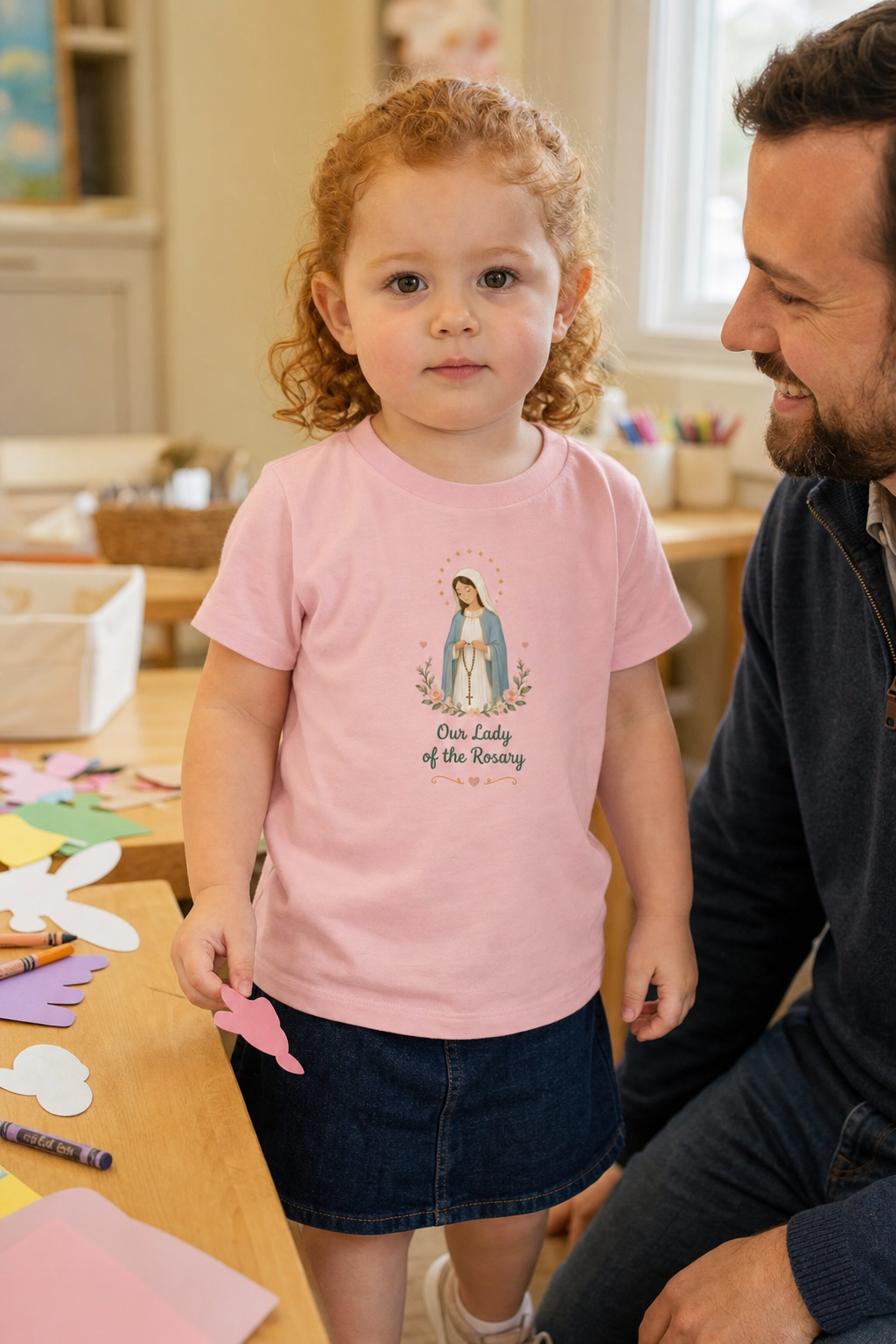 Little girl wearing the Our Lady of the Rosary Toddler T-Shirt in Pink