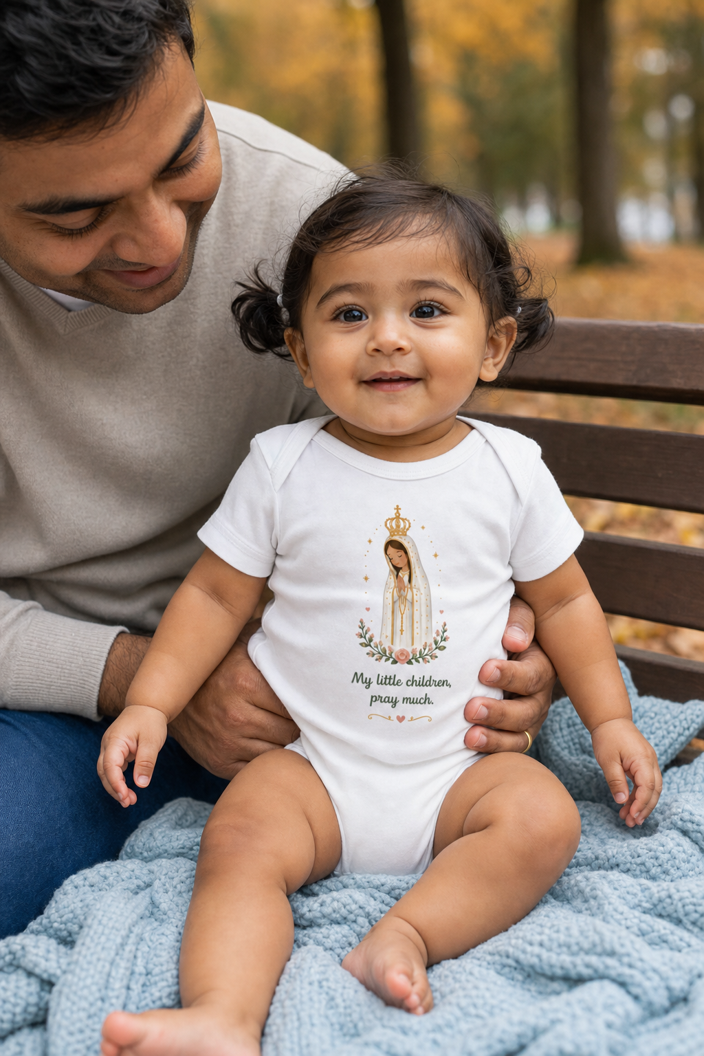 Baby girl wearing the Pray Much Fátima Baby Bodysuit in White