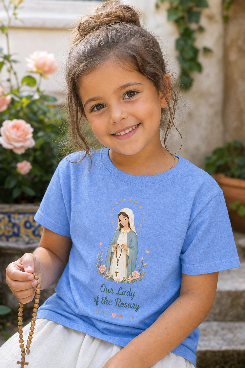 Little girl wearing the Our Lady of the Rosary toddler T-shirt in a lifestyle setting — detail