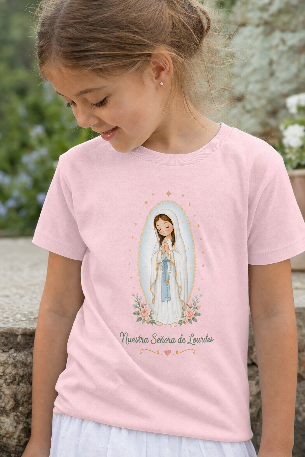 Little girl wearing the Nuestra Señora de Lourdes toddler T-shirt in a lifestyle setting — detail
