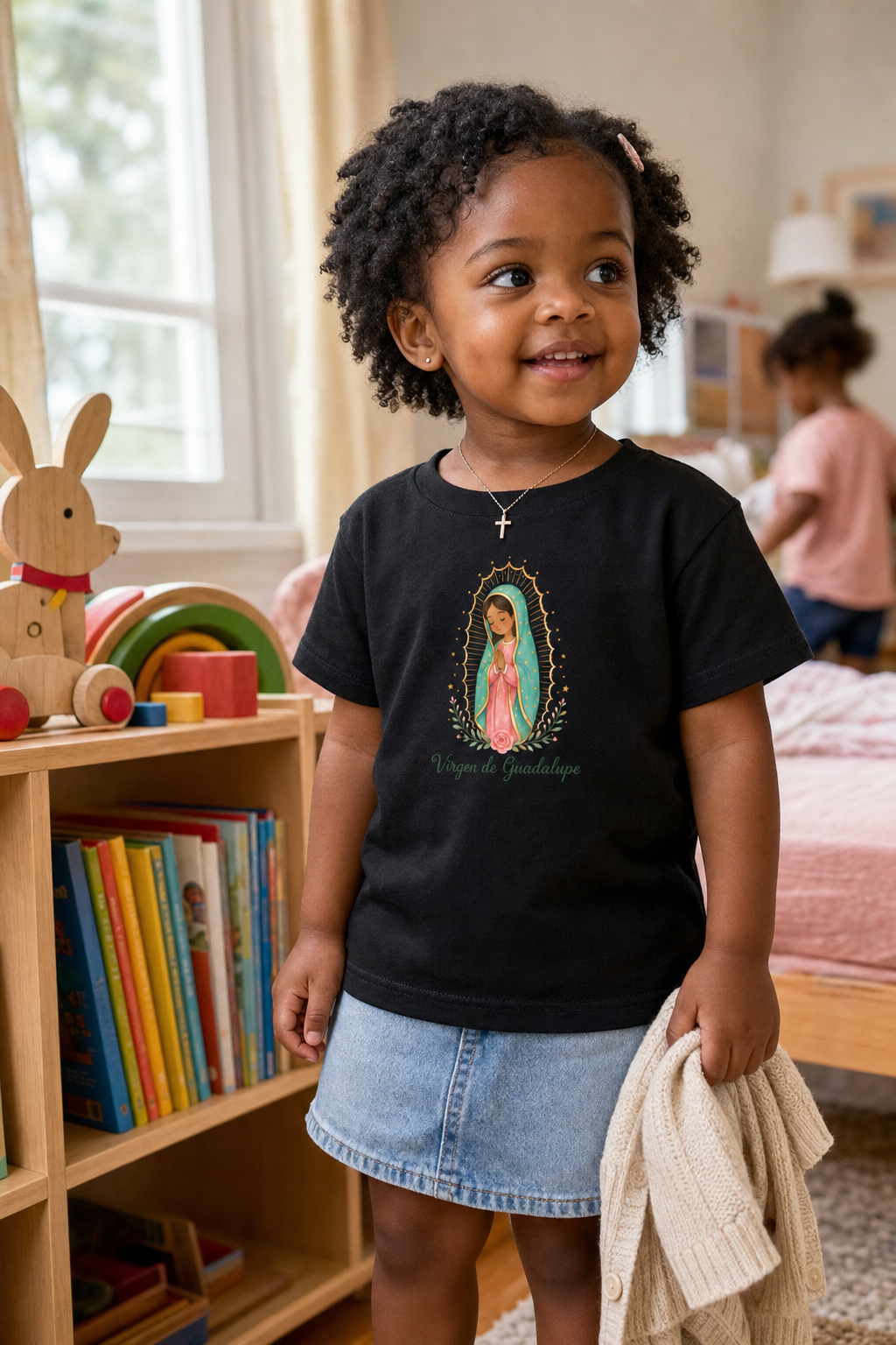 Little girl wearing the Virgen de Guadalupe Toddler T-Shirt in Black