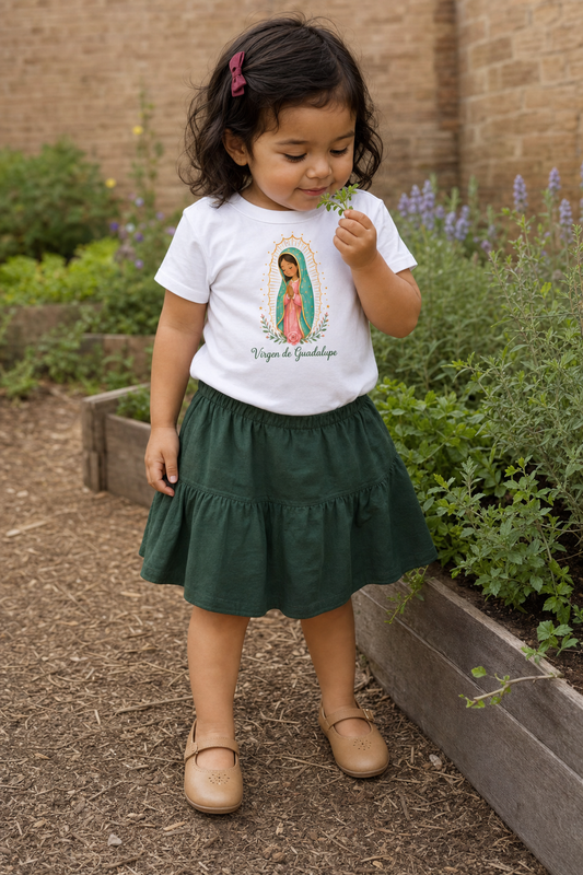 Little girl wearing the Virgen de Guadalupe Toddler T-Shirt in White