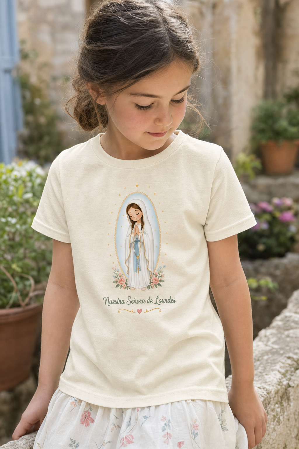 Girl wearing the Nuestra Señora de Lourdes Girls T-shirt in a lifestyle setting — detail